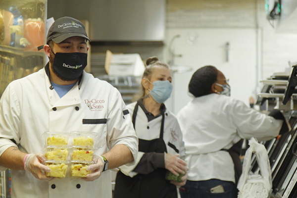 Staff with masks preparing food